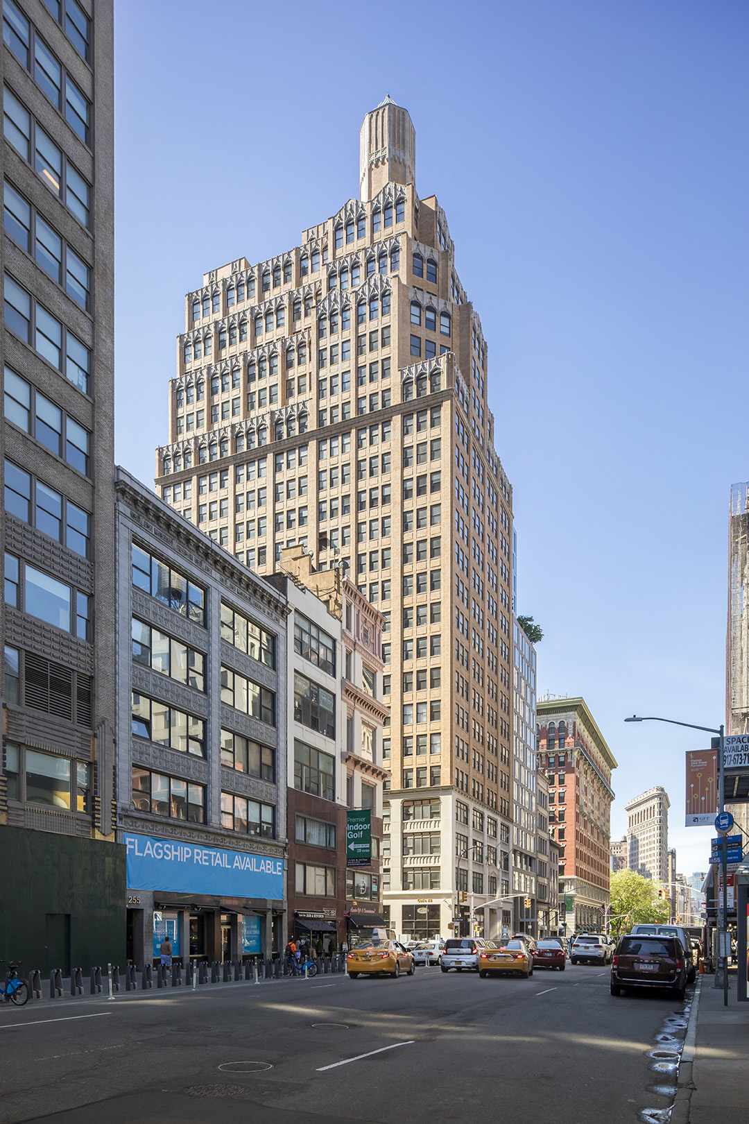 a city street filled with traffic surrounded by tall buildings